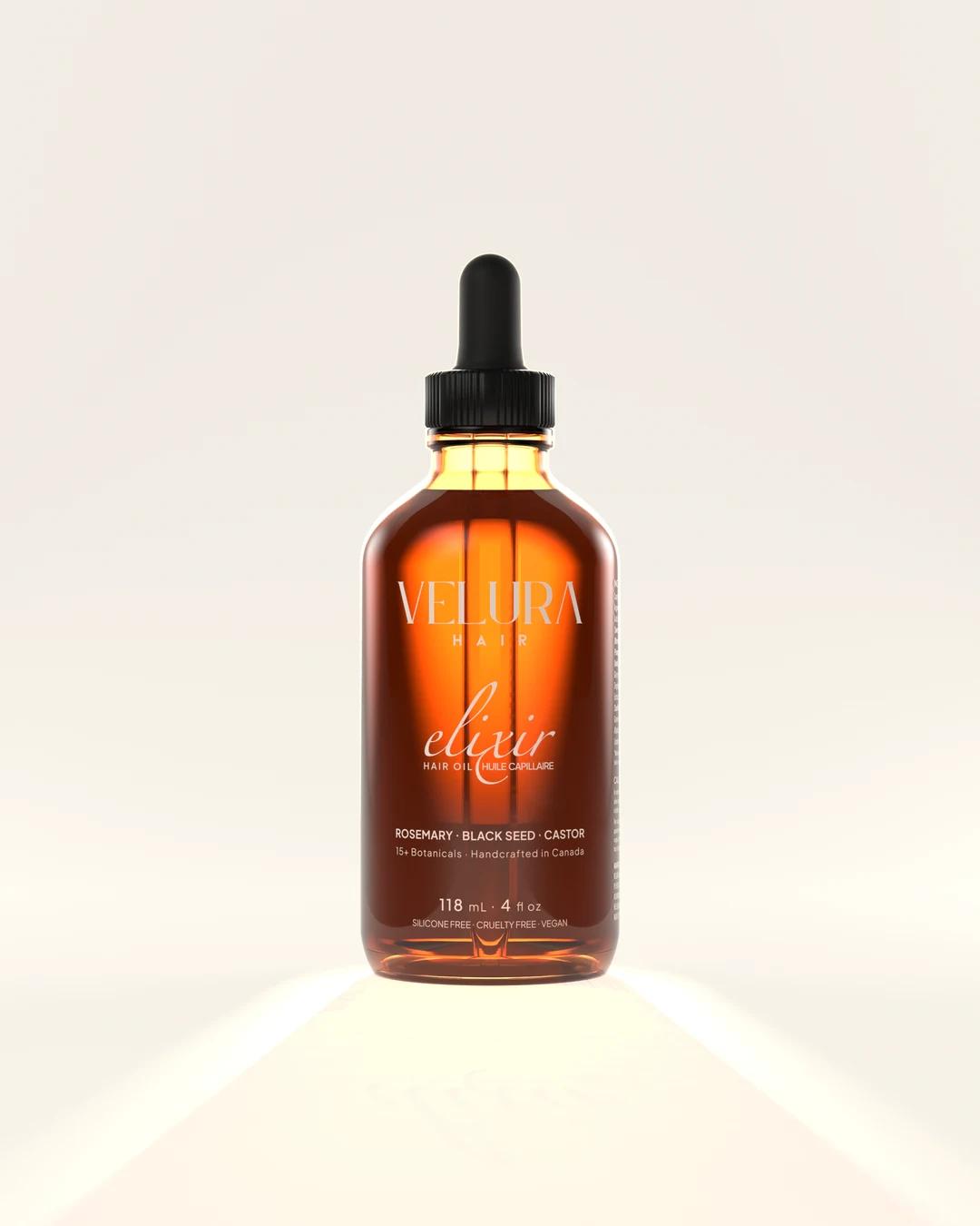 An amber glass bottle of Velura Elixir turning slowly in warm studio light
